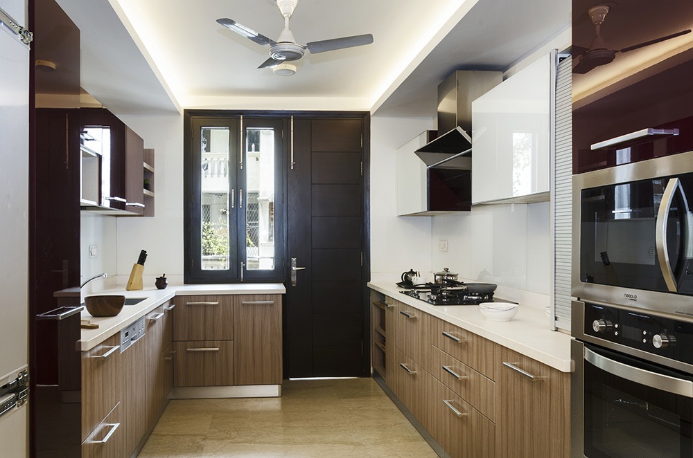 Wooden Parallel Kitchen And White Cabinets by Mridul Jain